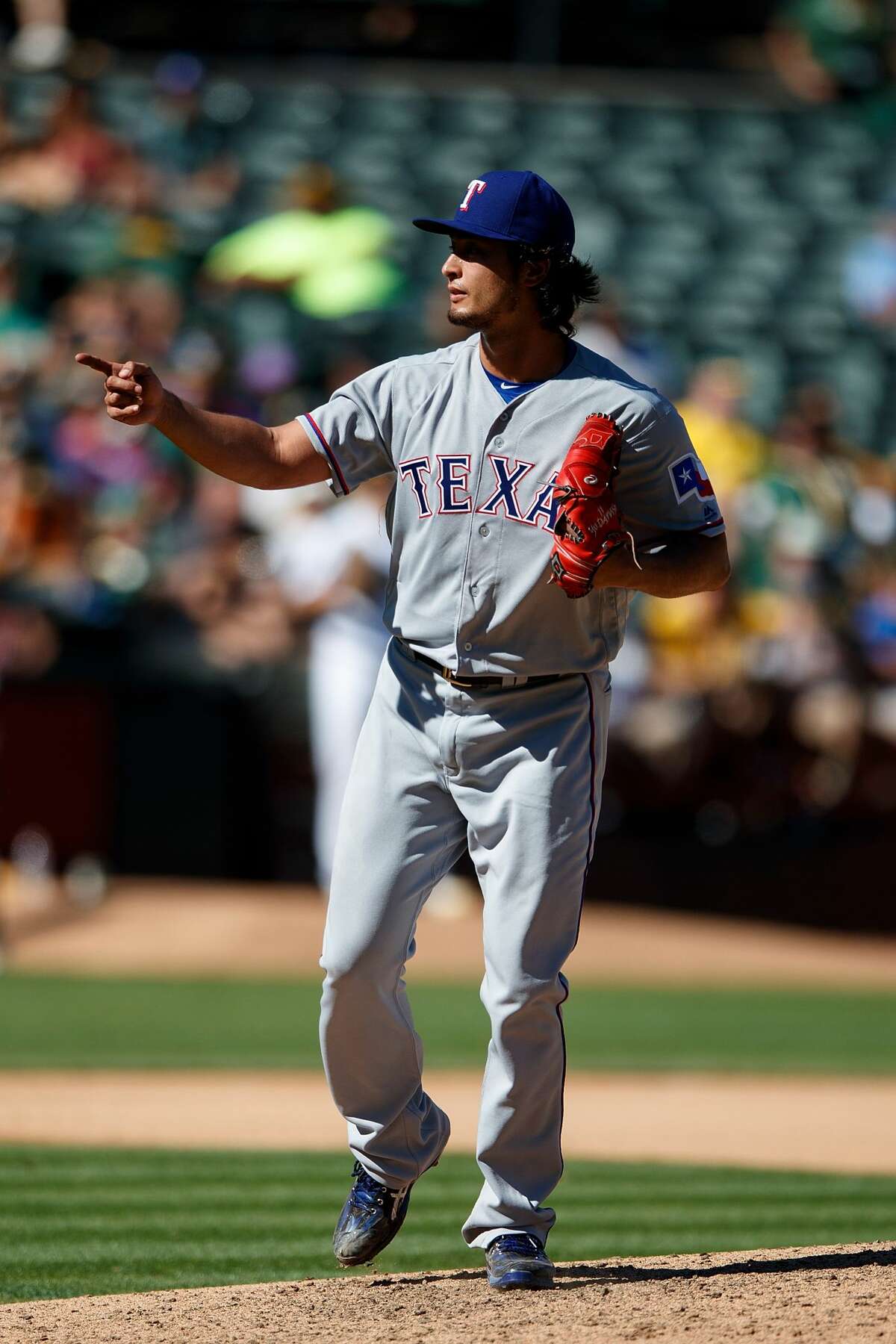 OAKLAND, CA - SEPTEMBER 24: Yu Darvish #11 of the Texas Rangers celebrates after striking out Yonder Alonso (not pictured) of the Oakland Athletics during the seventh inning at the Oakland Coliseum on September 24, 2016 in Oakland, California. The Texas Rangers defeated the Oakland Athletics 5-0. (Photo by Jason O. Watson/Getty Images)