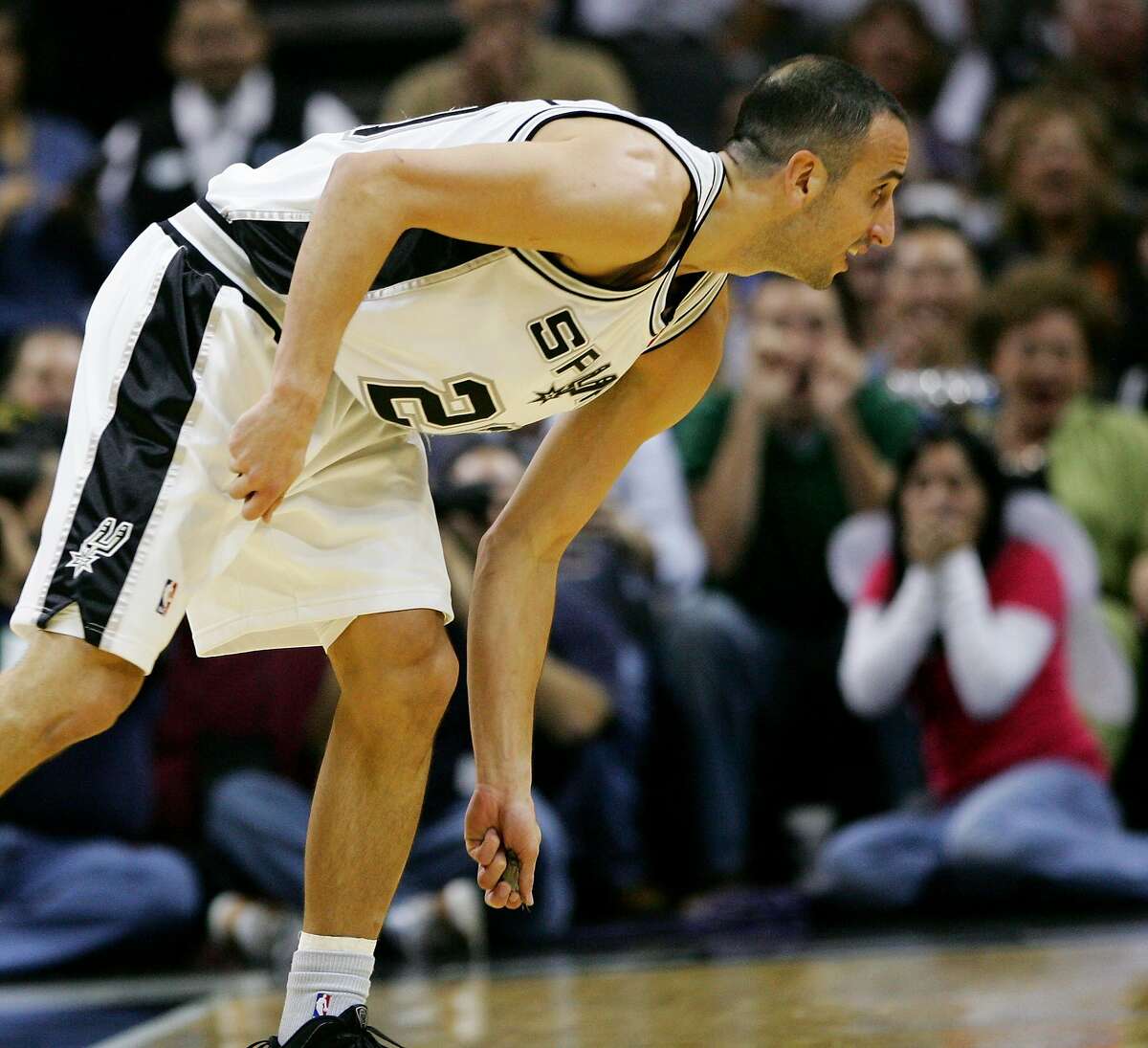 San Antonio Spurs guard Manu Ginobili picks up a bat to remove it from the court after swatting the animal from the air as it flew around the AT&T Center during the first half of an NBA basketball game against the Sacramento Kings, Saturday, Oct. 31, 2009, in San Antonio. (AP Photo/Darren Abate)