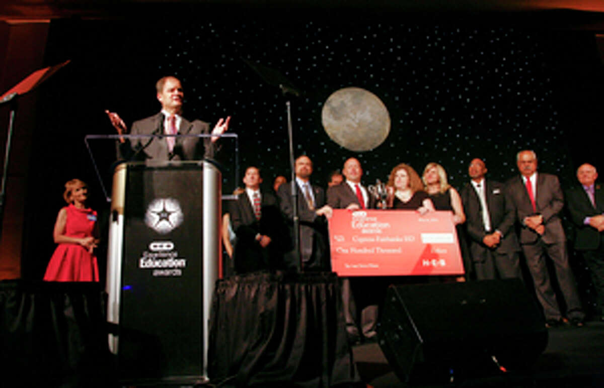 Dr. Mark Henry, superintendent of schools, accepts the H-E-B Excellence in Education award for large districts during the awards ceremony on Sunday in Houston. Members of the Board of Trustees and administrative team display the trophy and check worth $100,000 from the stage.