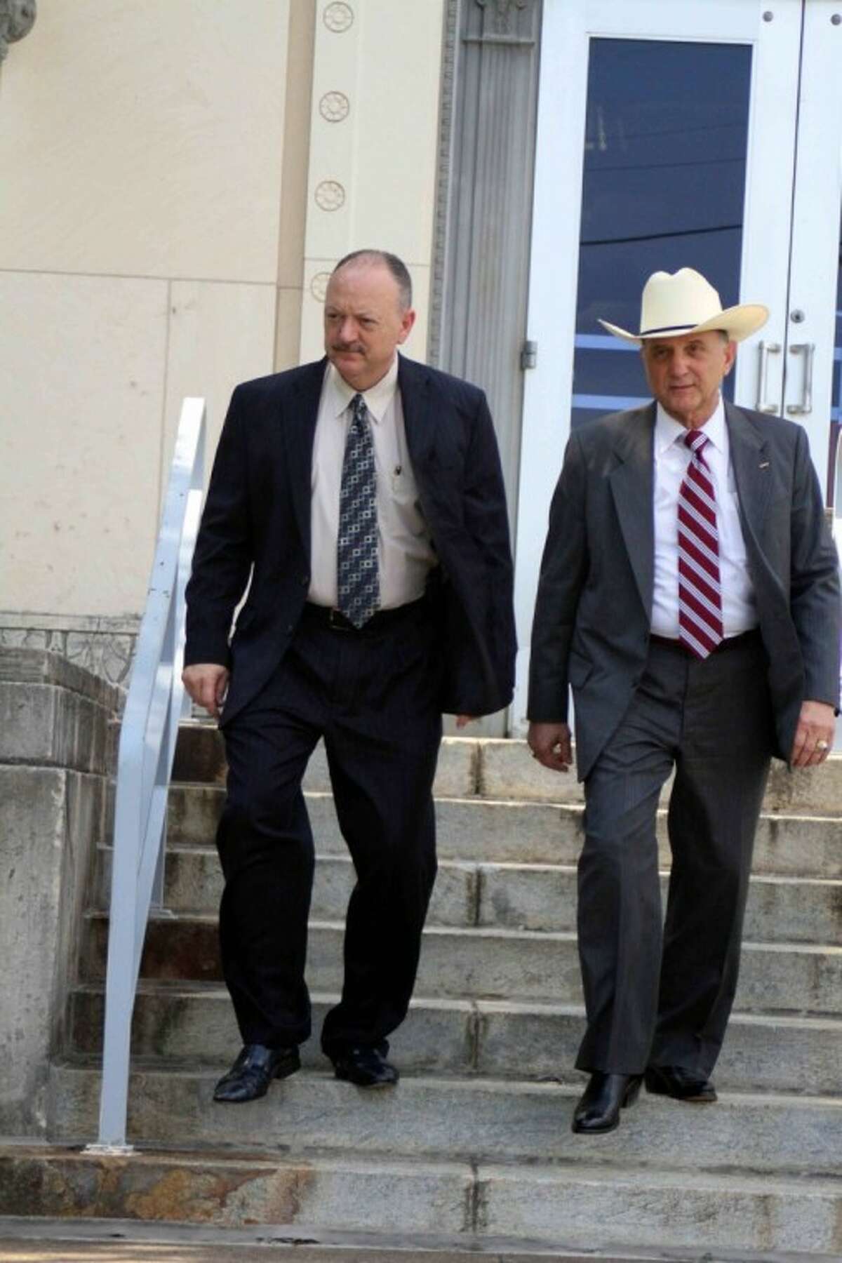 Harry Kelley (left) leaves the federal court building in Beaumont following his sentencing hearing. He is accompanied by his attorney, Jack Zimmermann. Kelley had initially left the building but returned to face media at the urging of his attorney. Kelley plans to appeal his conviction for two counts of mail fraud and one count of possession of stolen ammunition.