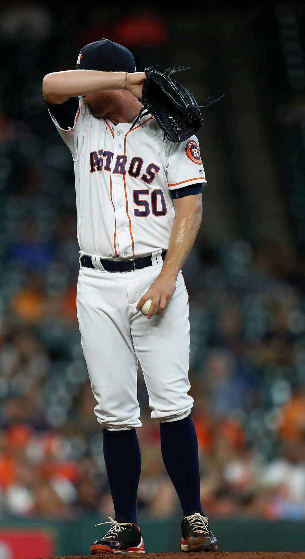 Houston Astros relief pitcher Kevin Chapman (50) wipes his face after giving up a run during the third inning of an MLB game at Minute Maid Park, Wednesday, Sept. 28, 2016 in Houston.