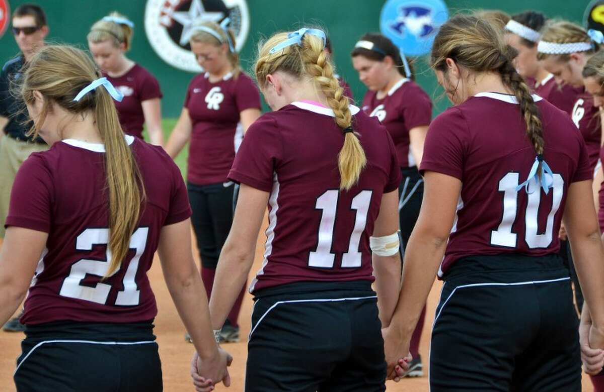 Cinco Ranch softball players gather in a prayer circle before the start of an area playoff game against Aldine MacArthur May 5. The prayer circle was in memory of umpire Ricky Scearce, Jr., a Katy resident who died of a heart attack on the field during a game between the two teams the night before.
