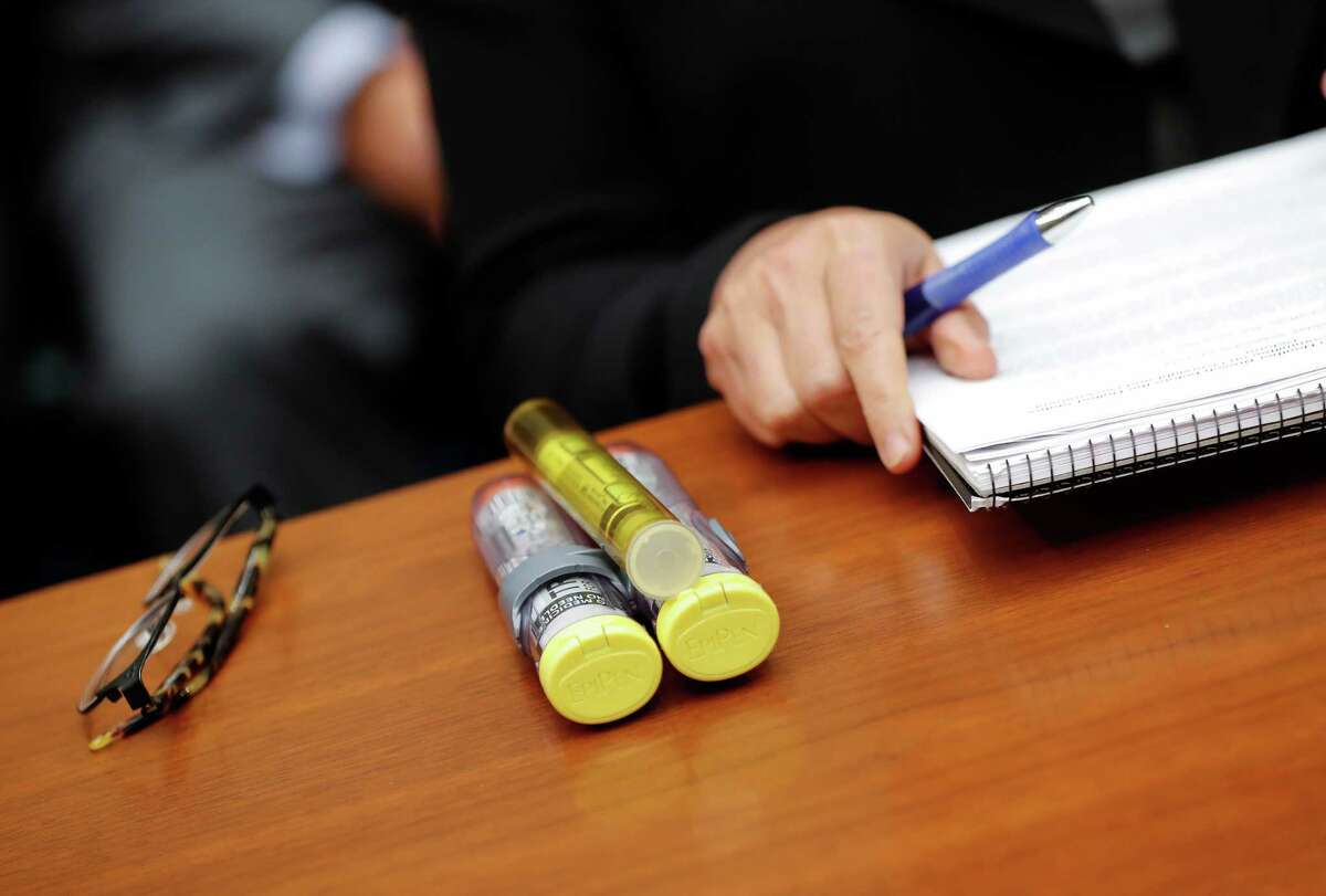 FILE - In this Sept. 21, 2016 file photo, EpiPens brought by Mylan CEO Heather Bresch are seen on Capitol Hill in Washington as she testified before the House Oversight Committee hearing on EpiPen price increases. Senators are asking the Justice Department to investigate whether pharmaceutical company Mylan acted illegally when it classified its life-saving EpiPen as a generic drug and qualified for lower rebate payments to states. (AP Photo/Pablo Martinez Monsivais, File) ORG XMIT: WX109