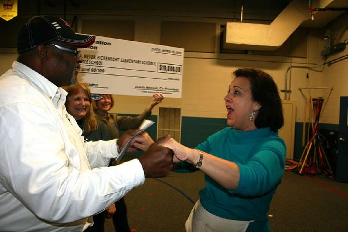 Charlotte Hatley, Ponderosa Elementary School music teacher, shows her surprise as Ken Grays, Spring ISD Education Foundation board director, informs her that she is a grant winner. Ponderosa Principal Deborah Graham looks pleased while Courtney Bryan, Foundation board director displays a big check in the background.