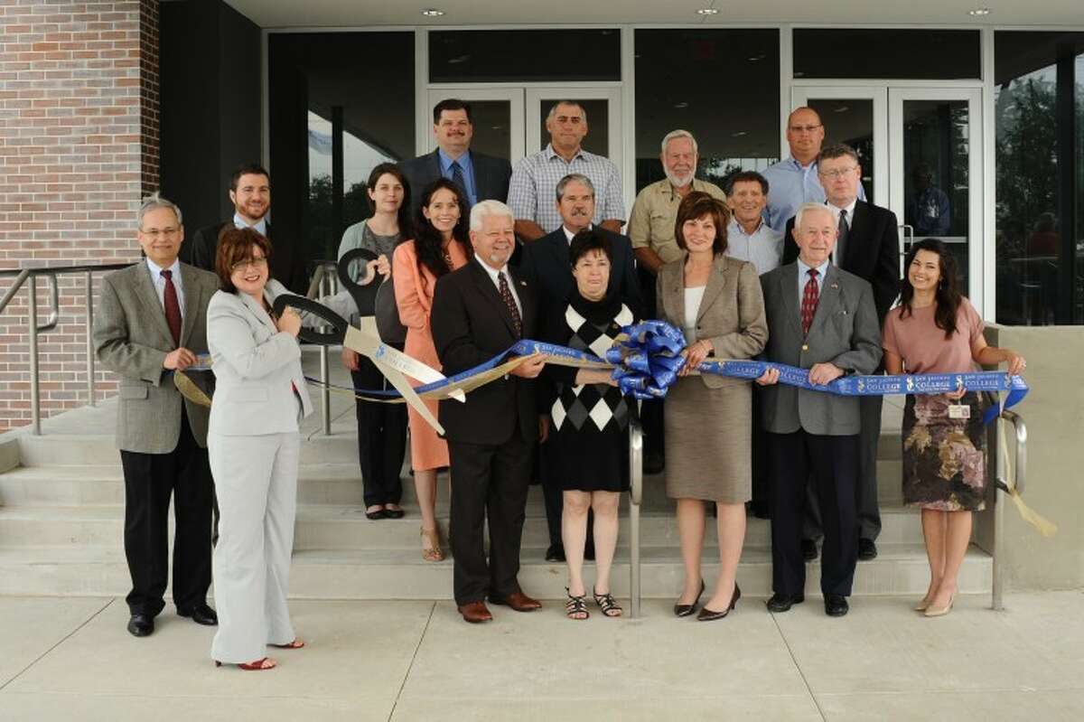 Local elected officials, school officials and contractors stand as San Jacinto College South Campus President Dr. Maureen Murphy ceremoniously cuts the ribbon dedicating a new Welcome Center and Academic Hall during a ceremony Tuesday, May, 15.