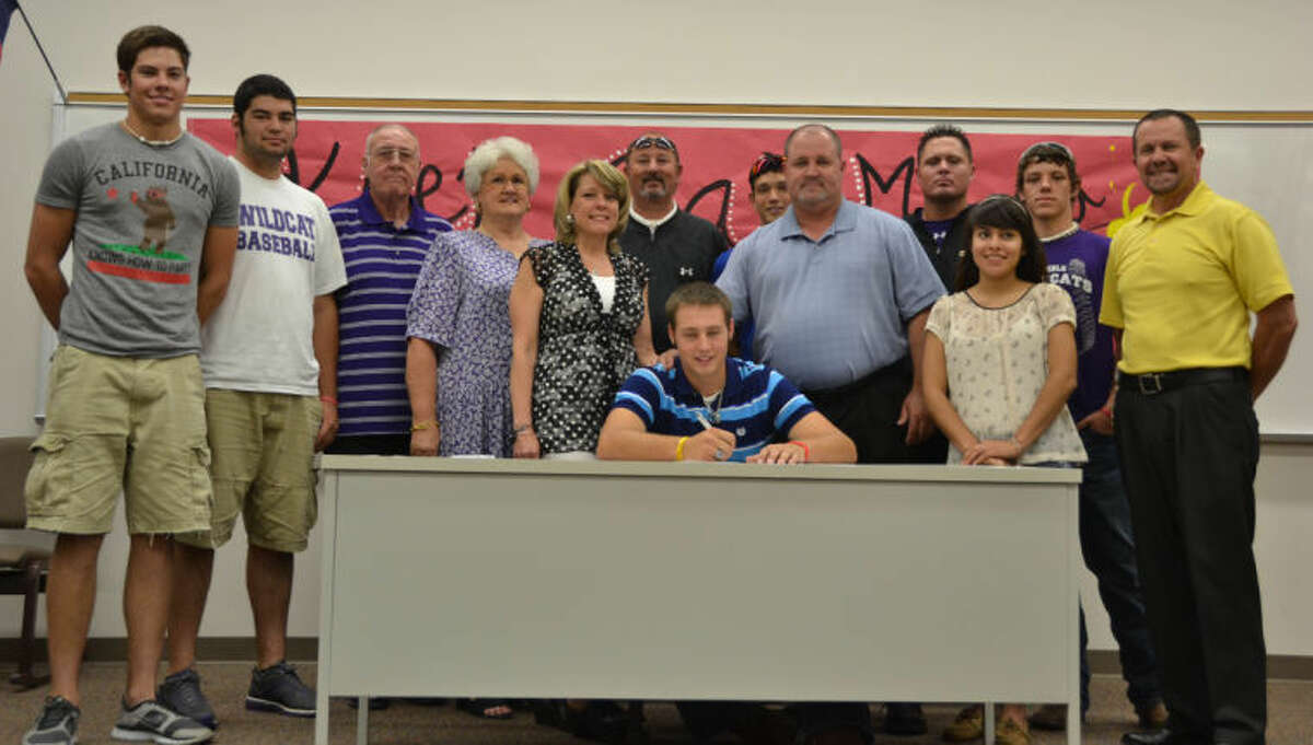Surrounded by friends, family and coaches, Humble pitcher Cody Martin signs a letter of intent to pitch for Angelina College at a ceremony at Humble High School last week.