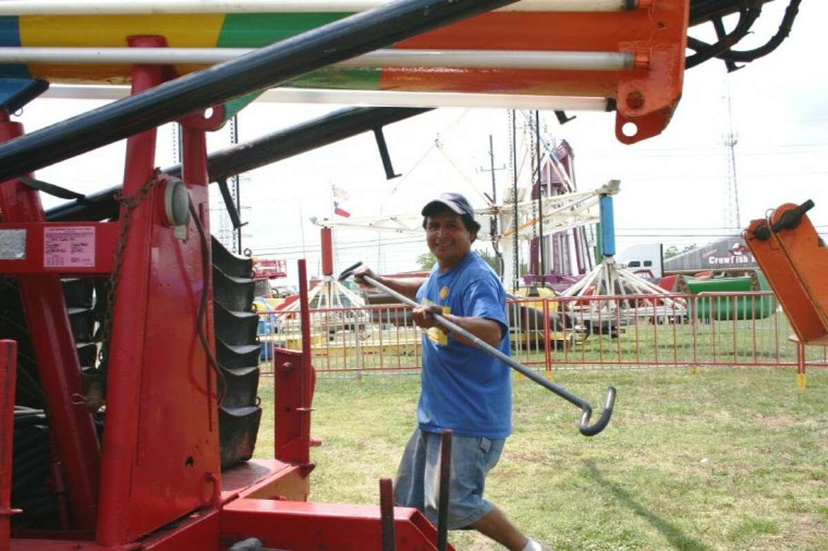 Marcello Mendez with Jim's Rides helps to assemble the popular children's amusements at the Crosby Fair & Rodeo grounds. The 66th Annual Fair & Rodeo would be held June 1-9.