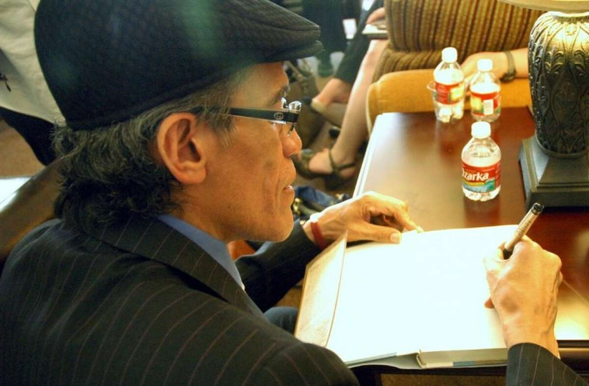 Williams signs a copy of his book, "A Golden Voice."