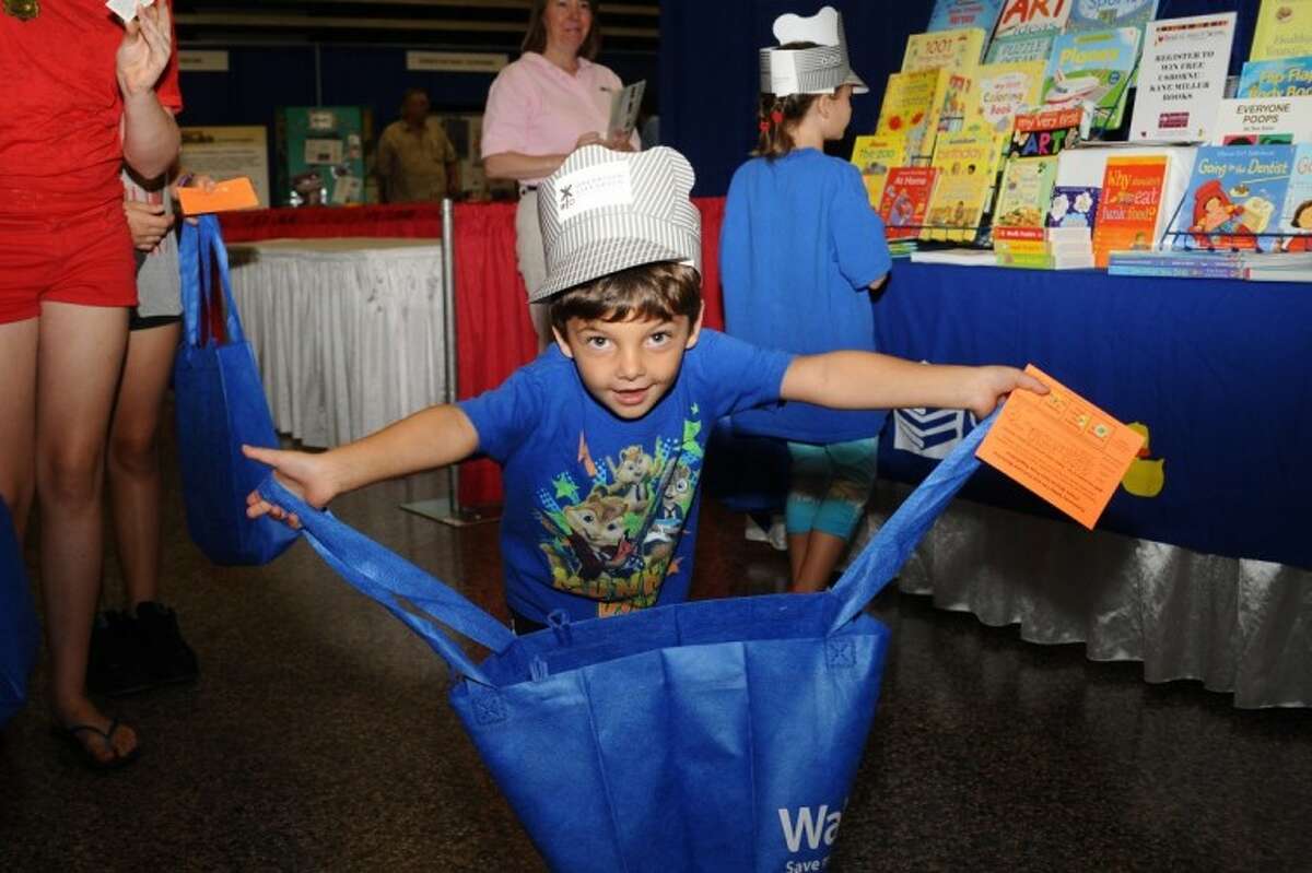 Justin Vychron show off the goodies that he collected during the Pasadena Hurricane Preparedness Fair Saturday, June 9.