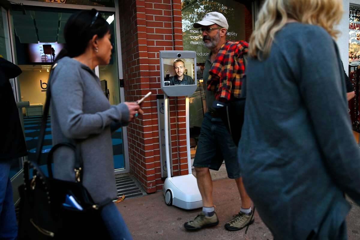 Salesperson Austen Trainer of Davis watches pedestrians walk by outside of Suitable Technologies' Beam store in Palo Alto, Calif., on Wednesday, September 28, 2016.