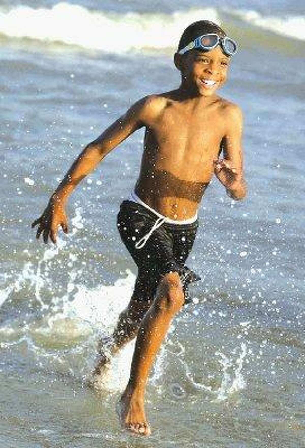 Beaumont resident Marcus Mitchell has some fun in the waves during a trip to Galveston Island with his family.
