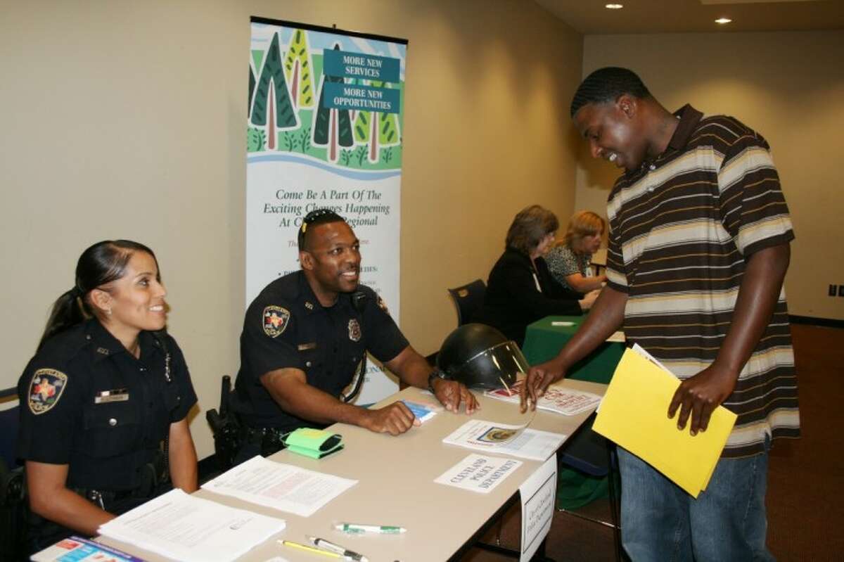 Stephen Davis learns about career opportunities at Cleveland Police Department from Officers Veronica Johnson and Jared Taylor during the June 26 job fair hosted by the Greater Cleveland Chamber of Commerce.