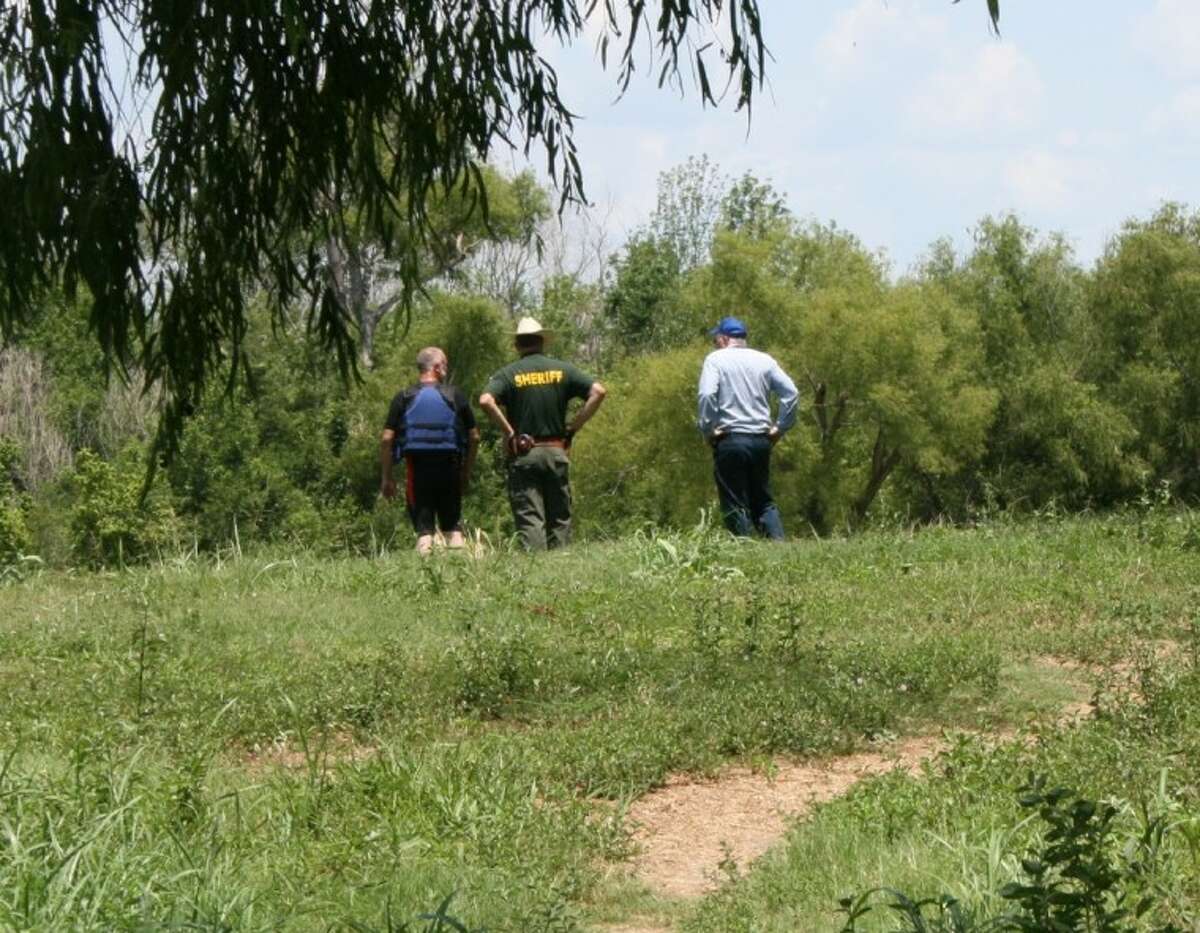 Capt. Carl Jones (center) with the San Jacinto County Sheriff's Office looks out over the water where a 6-year-old Houston boy went missing Friday, July 6, near Lake Livingston.