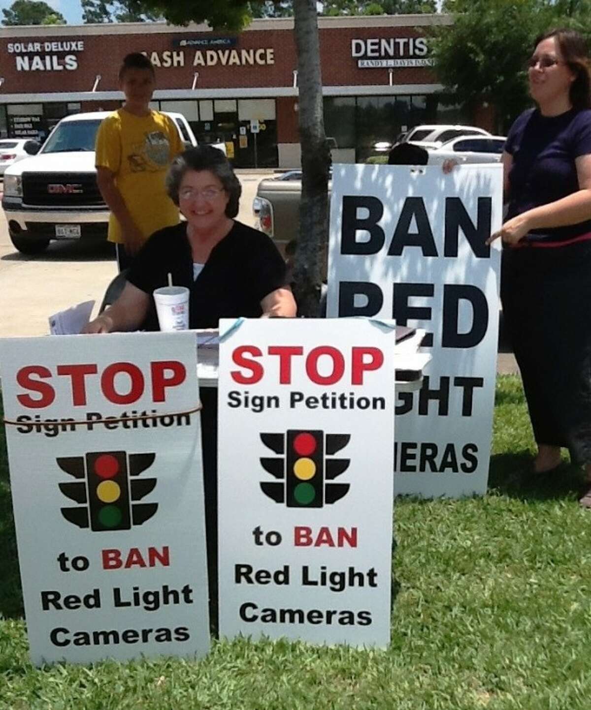 Opponents of Cleveland's red light camera system gather near Walmart to collect signatures in order to have the devices removed.