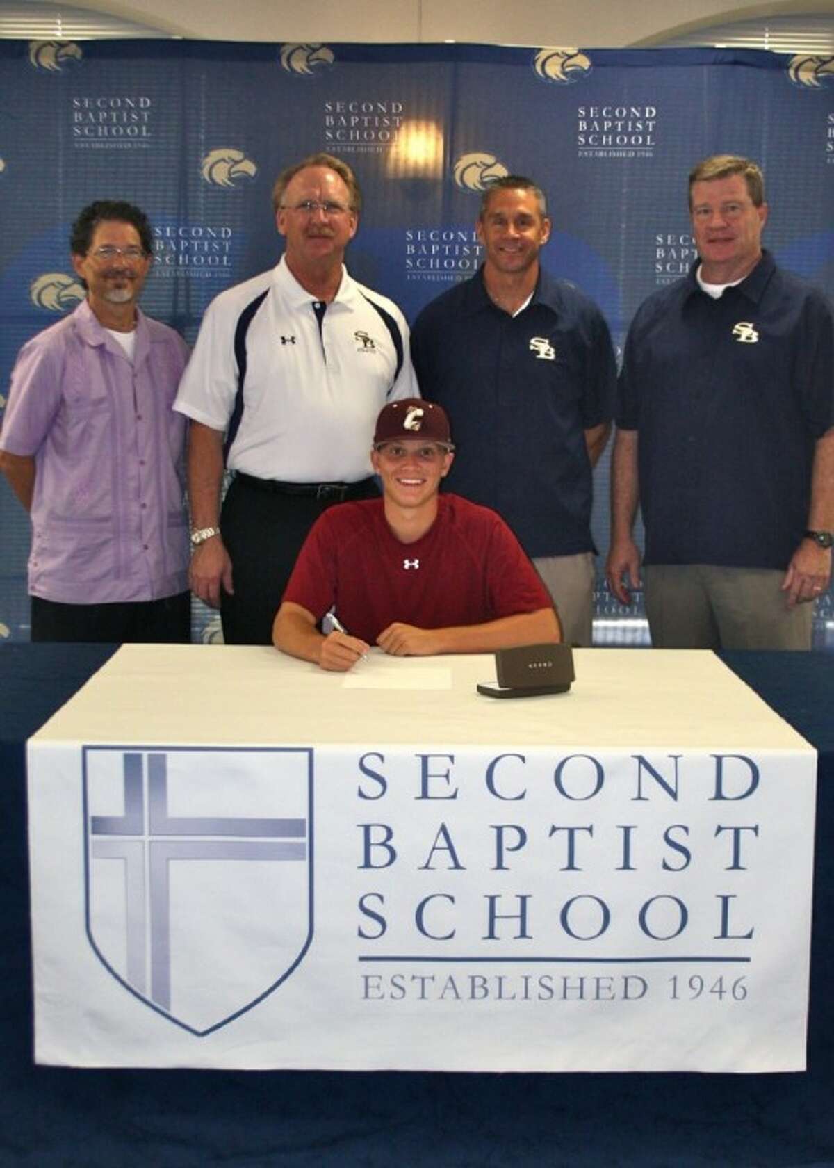 SUBMITTED PHOTO: Second Baptist catcher/outfielder Garrett Luce signs with College of Charleston. He’s pictured here with Second Baptist trainer Brad Cooper and coaches Jeff Calhoun, Jeff Schroeder and David Dixon.