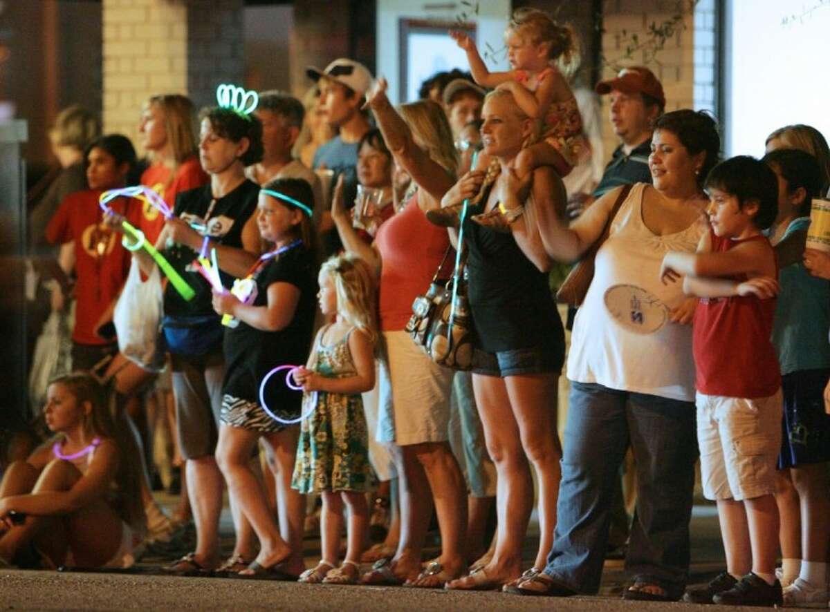 Residents line the street to watch the Parade of Lights during Tomball Night on Friday.