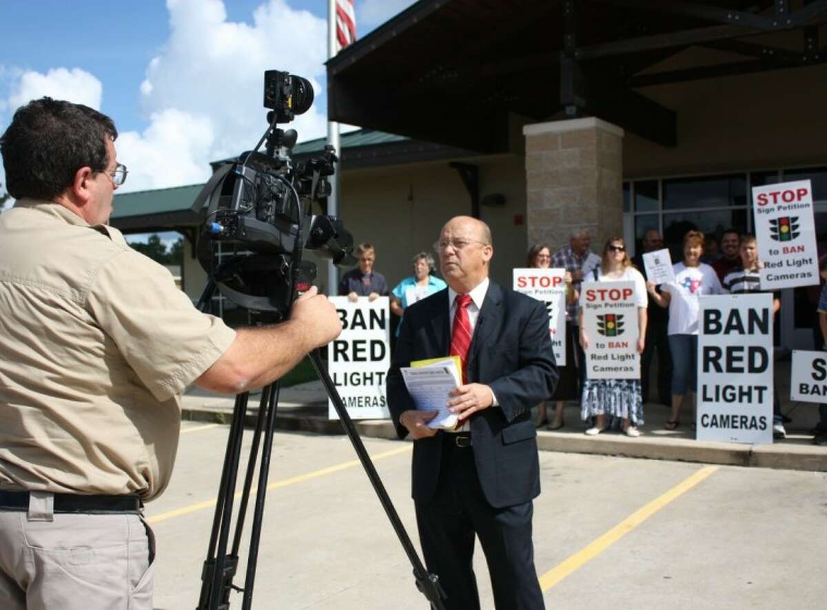 Aubrey Vaughan, center, of the Tri-County Texas Tea Party, is interviewed by television reporter Scott Engle, left, regarding the group’s efforts to remove Cleveland’s red light cameras. The group turned out on July 16 to turn in nearly 1,000 signatures of residents and nonresidents that signed a petition calling for the lights to be removed.