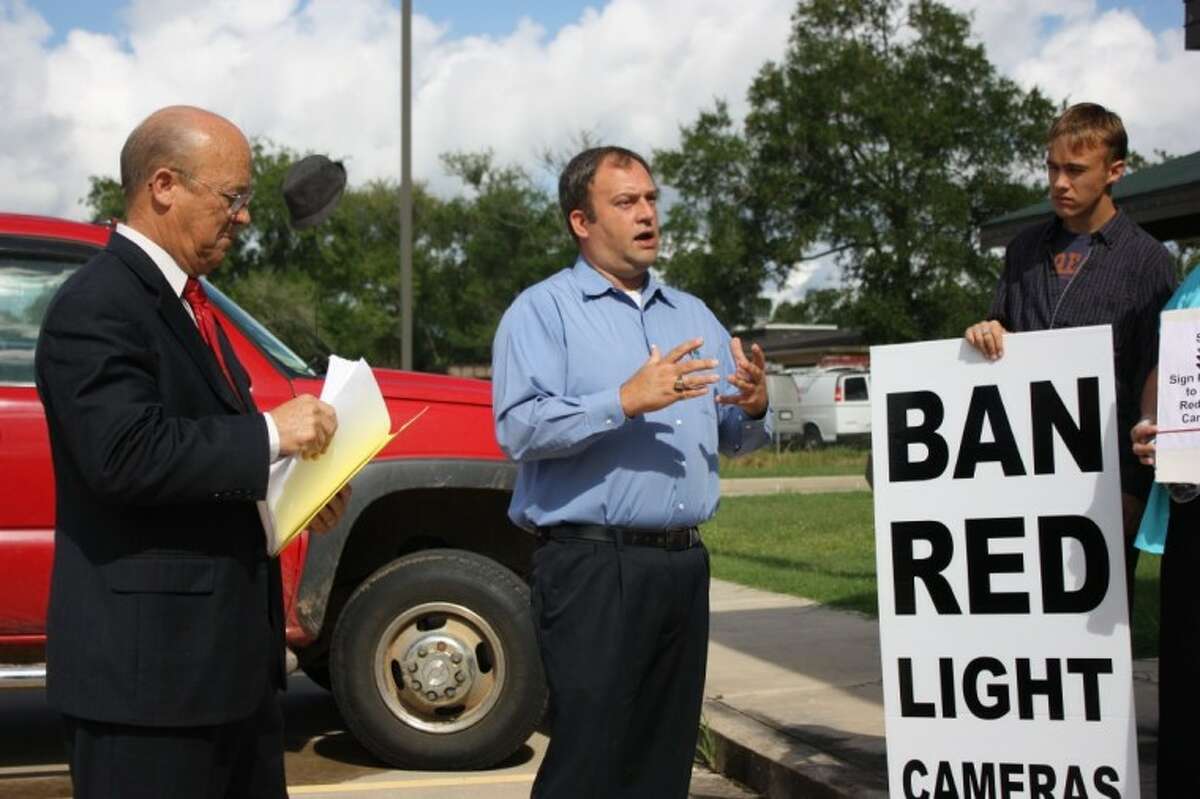 Byrom Schirmbeck, center, a Baytown resident that led that city’s effort to remove their red light cameras, as been assisting the Tri-County Texas Tea Party in Cleveland. Shown on the left is Aubrey Vaughan.