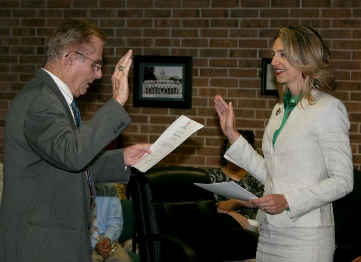 Former Galveston County judge Ray Holbrook administers the oath of office to new College of the Mainland board member Rachel Delgado.