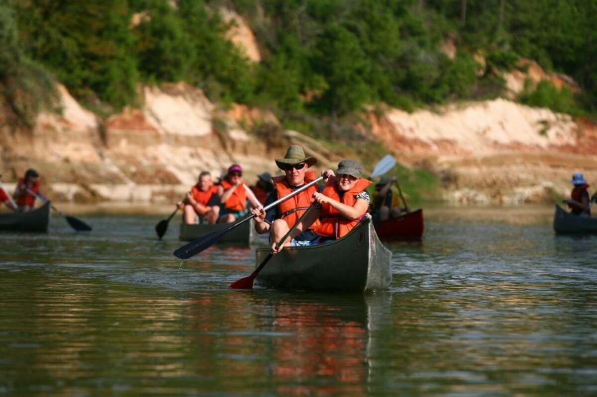 Canoes move up Spring Creek during the Bayou Land Conservancy's Canoes, Kayaks, and the Creek event on Saturday.