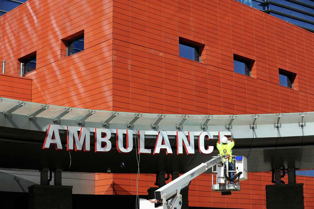 In mid-September 2016, a worker finalizes the “Ambulance” sign at Stamford Hospital in Stamford, Conn. On Sept. 27, the Connecticut Insurance Department revealed a proposed 10.9 percent reduction in the average loss costs charged by workers compensation insurers, a major component of overall workers comp rates.