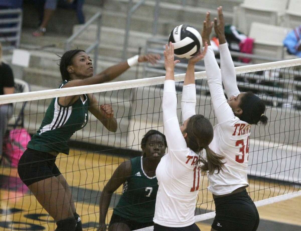 Travis' Lindsey Davenport and Alona Word try to block a shot by Hightower's Essance Preston during an Oct. 2 match at Buddy Hopson Field House in Missouri City. Travis won in three, 25-15, 25-11, 25-20, to improve to 6-2 in District 23-5A.