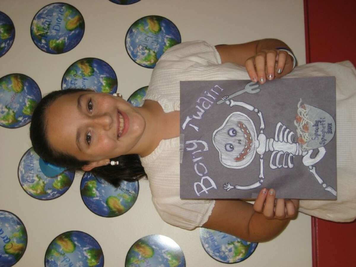 Natalia Cardone, a fifth-grader at Mark Twain Elementary, displays her winning t-shirt design for the school’s upcoming Spooky Spaghetti dinner and festival.