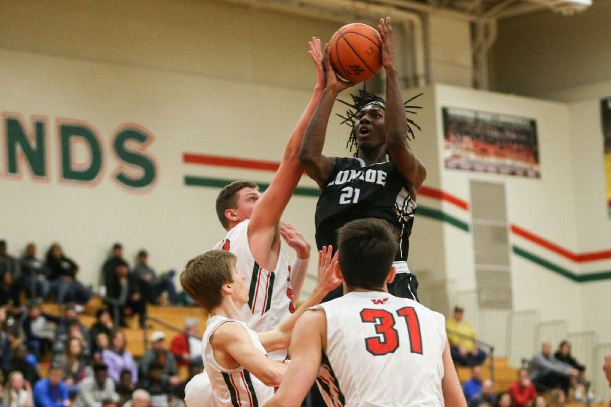 Conroe’s Tremont Moore (21) moves inside for a shot against The Woodlands.