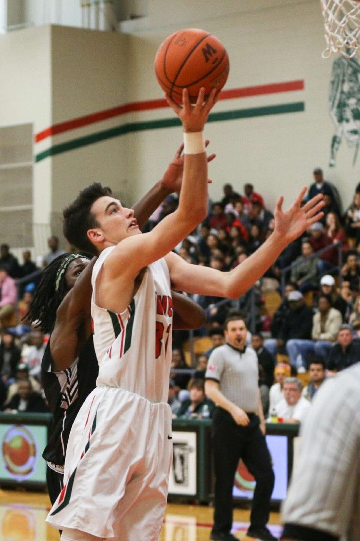 The Woodlands’ Carter Freas (31) goes for a layup during the high school boys basketball game against Conroe.