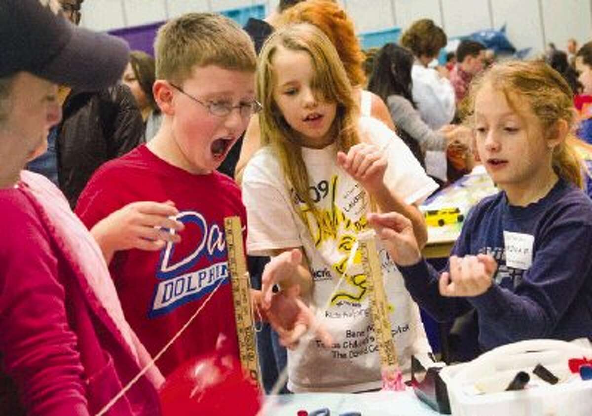 David Elementary School students Nathan Wrigley, left, Lauren Novak and Marina Palandro demonstrate their science fair project to a crowd of onlookers Saturday during the Elementary School Science Festival at the SCI://TECH Exposition hosted by Education for Tomorrow Alliance at the Lone Star Convention & Expo Center in Conroe. The students released an inflated balloon and then measured the distance it travelled during one of their experiments. To view or purchase this photo and others like it, visit HCNpics.com.