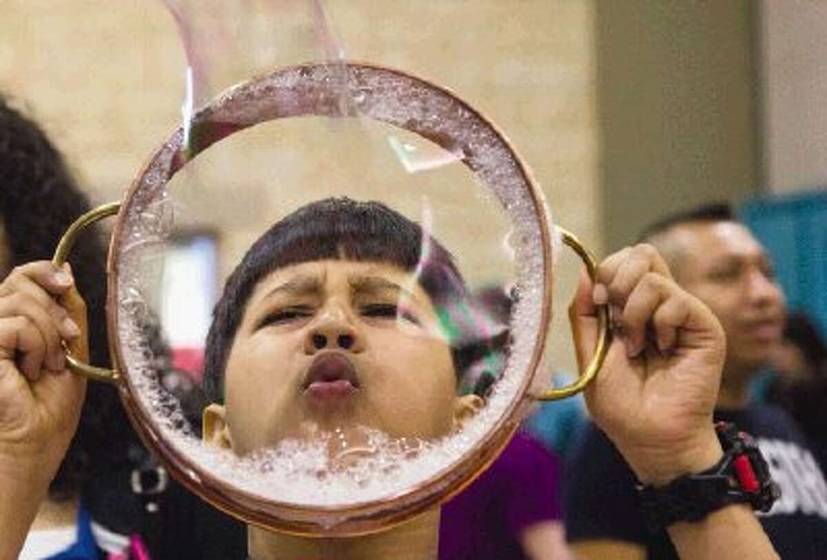 Lamar Elementary School student Rishab Patil, 9, blows a giant bubble at Deretchin’s Bubble Factory, a science fair project created by a kindergarten class at Deretchin Elementary School during the annual SCI://TECH Exposition at the Lone Star Convention & Expo Center Saturday in Conroe. To view or purchase this photo and others like it, visit HCNpics.com.