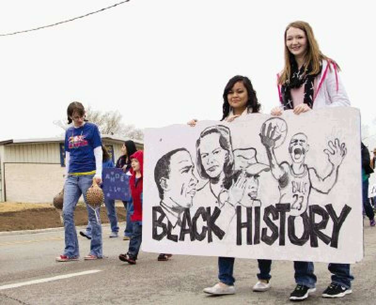 Two girls hold a sign made by Anderson Elementary minutes before The J-Mac 56th Annual Black History Parade kicked off in downtown Conroe on Saturday. The parade was officially named the J-Mac Annual Black History Parade after organizers honored radio personality James Garrett, also known as J-Mac on 97.9 FM “The Box.” To view or purchase this photo and others like it, visit HCNpics.com.
