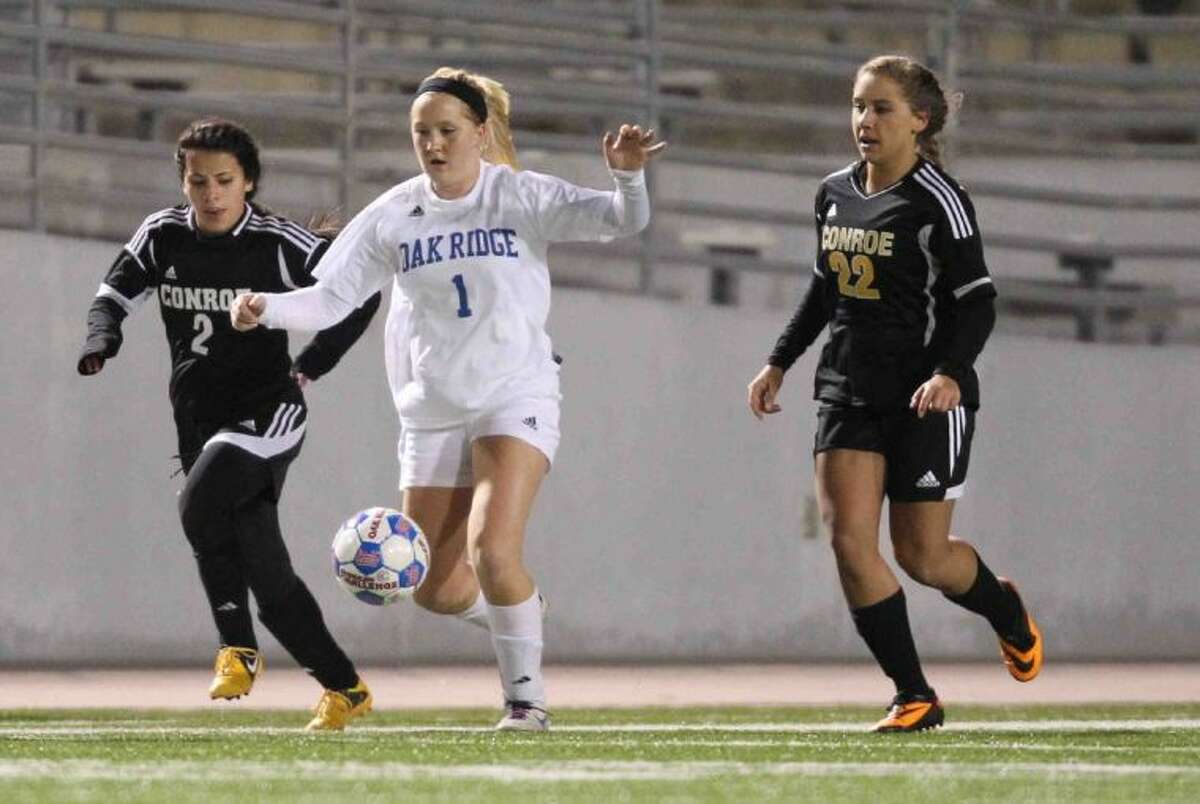 Oak Ridge midfielder Hailey Miller dribbles the ball downfield as Conroe’s Kassidy Hugenschmidt (22) and Nayari Arquieta (2) give chase during a District 14-5A match on Wednesday at Woodforest Bank Stadium. To view or purchase this photo and others like it, visit HCNpics.com.