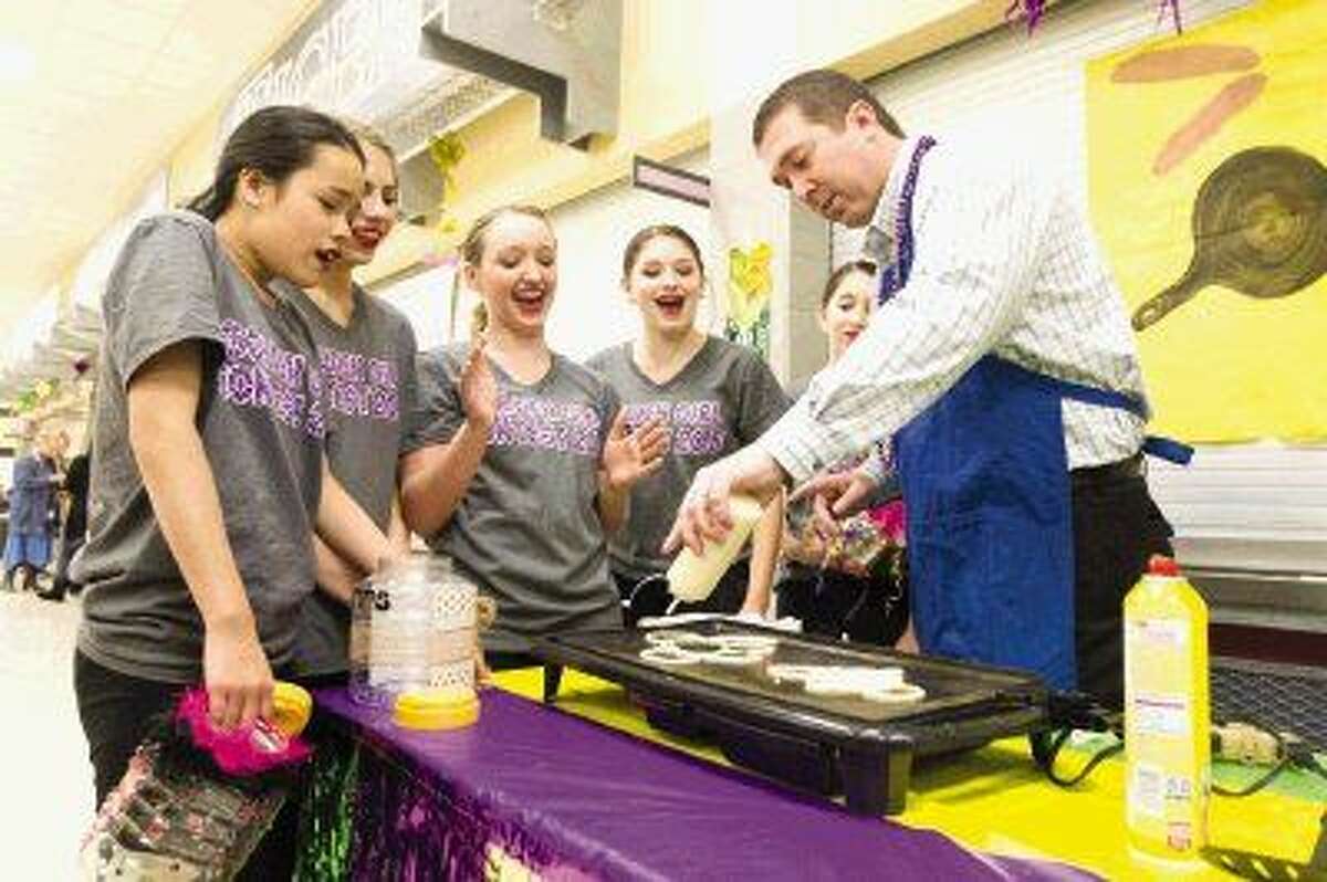 Conroe Principal Dr. Mark Weatherly demonstrates his pancake making skills to members of the Conroe Golden Girls during the organization’s annual pancake supper Tuesday at Conroe High School. To view or purchase this photo and others like it, visit HCNpics.com.