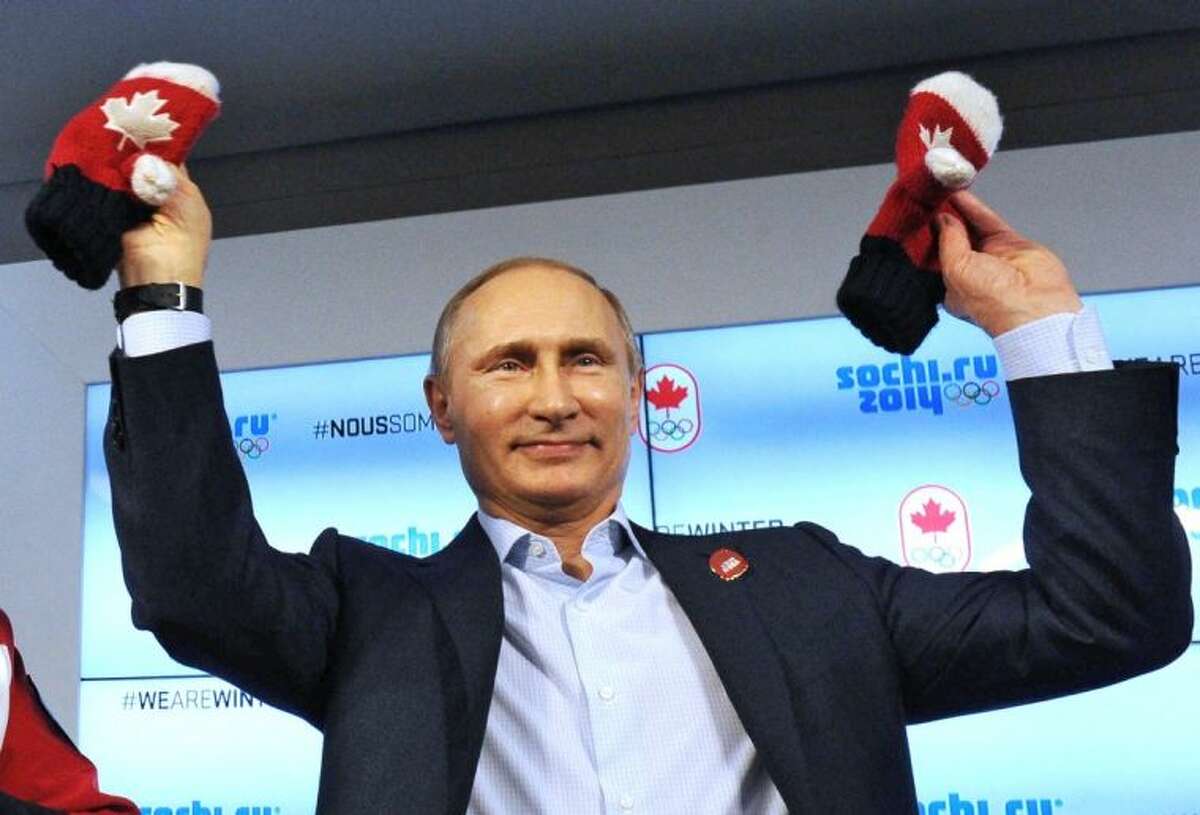 Russian President Vladimir Putin shows handmade mittens presented to him at Canada House during the 2014 Winter Olympics Friday in Sochi, Russia.