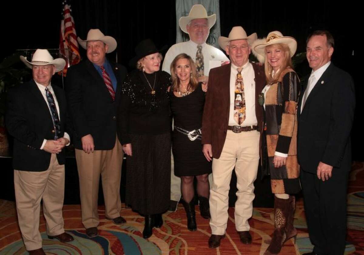 Local dignitaries surround Sheriff Tommy Gage, third from the right, both the real man and his cut out twin as the Woodlands Wine Dinner ended on February 1. The dinner honored Sheriff Gage this year.