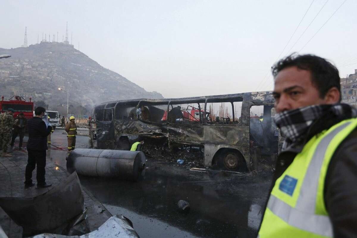 Afghan security guards on Dec. 13 inspect a damaged bus at the site of a suicide attack by the Taliban in Kabul, Afghanistan. The Afghan government is set to open a dialogue with Taliban insurgents it has been fighting for more than a decade, officials, diplomats and experts said Saturday.