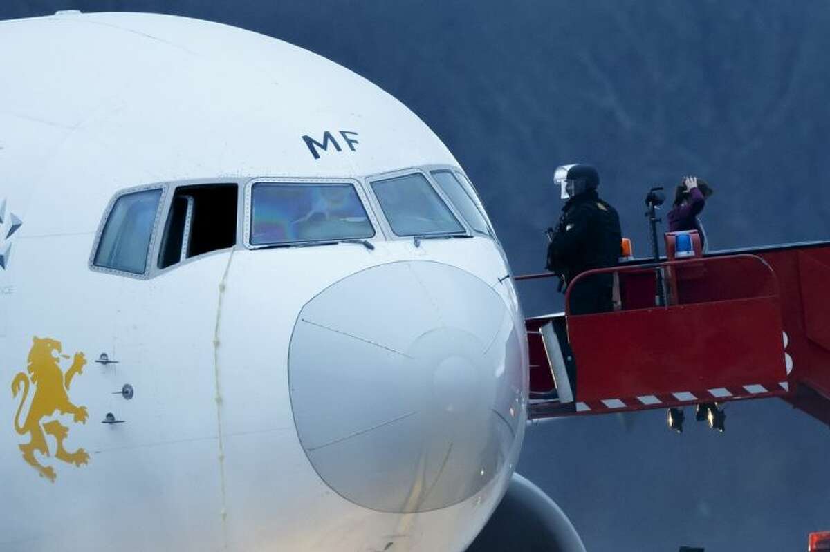 Police stand on the stairs after passengers were evacuated from a hijacked Ethiopian Airlines Plane on the airport in Geneva, Switzerland, Monday. The aircraft traveling from Addis Abeda, Ethiopia, to Rome, Italy, has landed at Geneva's international airport early Monday morning. Swiss authorities have arrested the co-pilot.