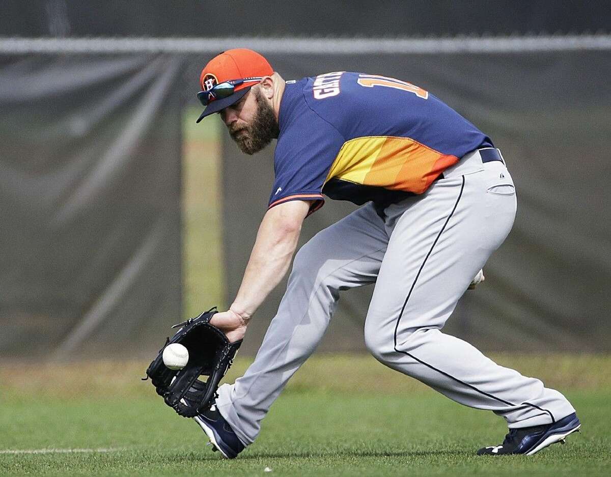 Houston Astros’ Evan Gattis fields a ground ball during a spring training baseball workout, Tuesday in Kissimmee, Fla.