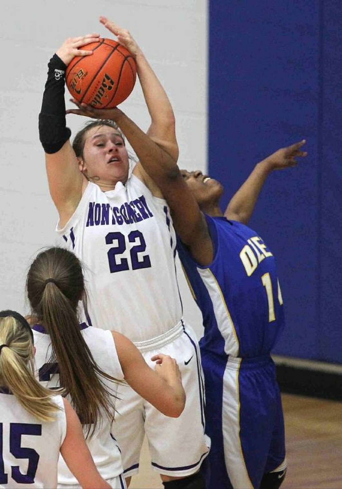 Montgomery’s Marissa Garcia grabs a rebound over Ozen’s Essyncce Templeton during a Region III-4A quarterfinal girls basketball game in Channelview Tuesday. To view or purchase this photo and others like it, visit HCNpics.com.