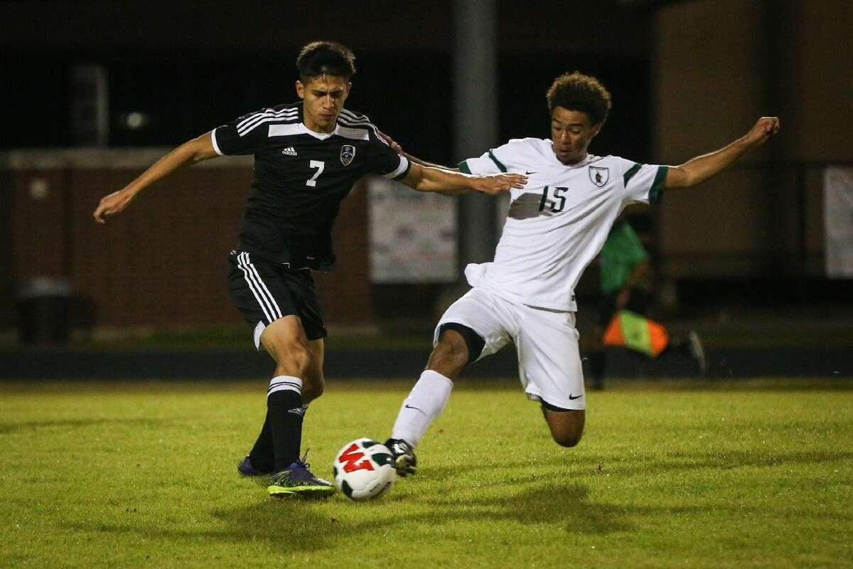 The Woodlands’ Wesley Mitchell (15) slides for the ball in front of Conroe's Jesus Velasco (7) on Tuesday at The Woodlands High School. To view more photos from the game, go to HCNPics.com.