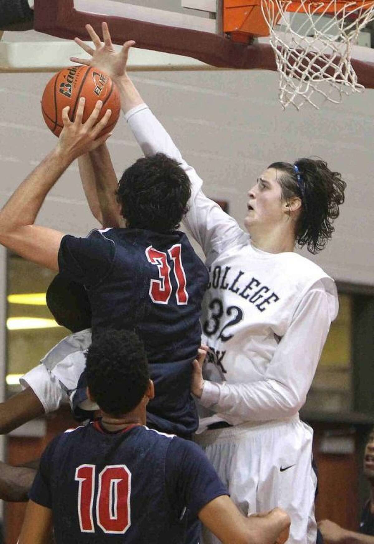College Park’s Brett Reed goes up to block a shot by Atascocita center Zach Haney during a Region II-5A regional quarterfinal playoff game at the M.O. Campbell Educational Center Tuesday. Atascocita defeated College Park 78-53. To view or purchase this photo and others like it, visit HCNpics.com.