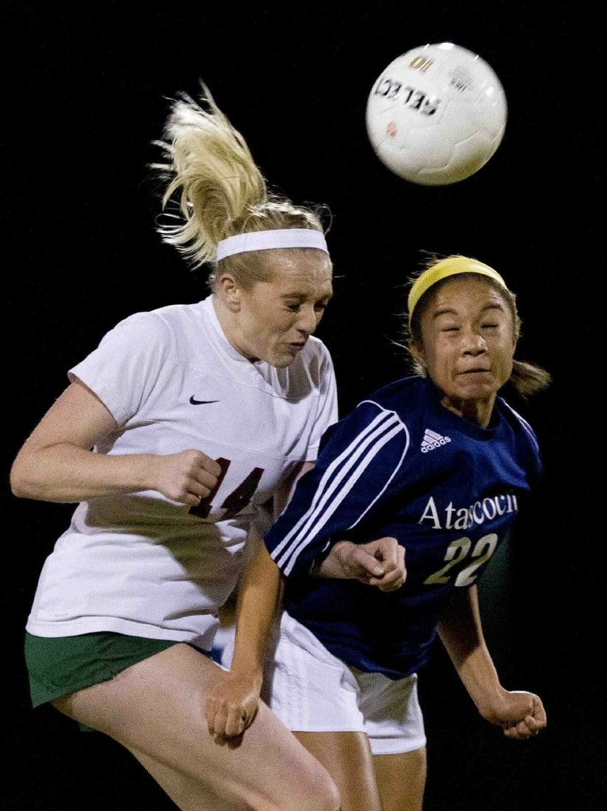 The Woodlands defender Emily Cox heads the ball past Atascocita midfielder Symone Lacour Friday.
