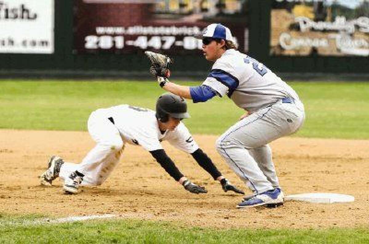 Conroe’s Wesley Johnson (19) slides back to first to avoid the pickoff attempt by Cy Creek pitcher Gabe Sequeira. To view more photos from the game go to HCNPics.com.