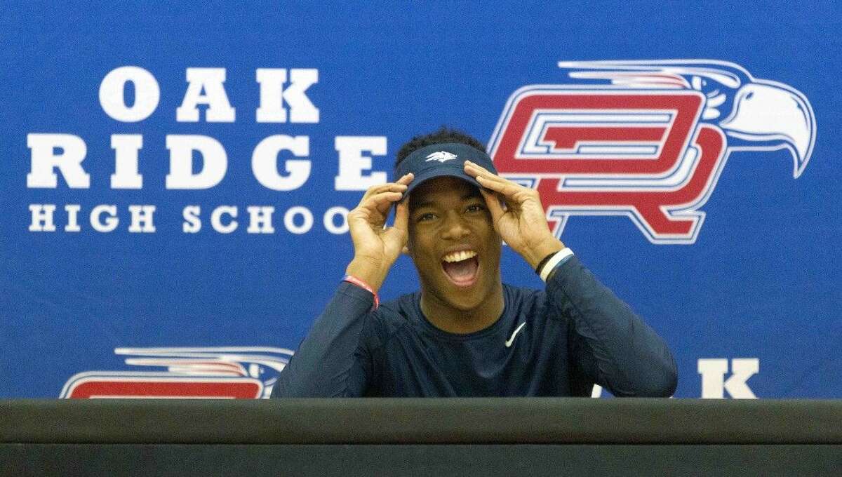 Oak Ridge’s Daylon Johnson reacts as the crowd cheers during a signing day ceremony Wednesday.