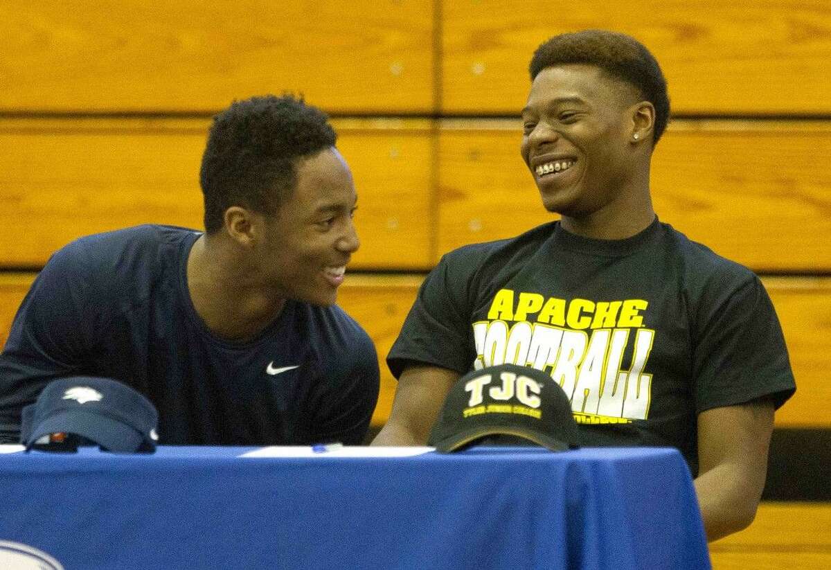 Oak Ridge's Josh Williams, right, laughs with Daylon Johnson during a signing day ceremony Wednesday. Williams and Johnson both signed to play football at the college level at Tyler Jr. College and University of Nevada respectively.