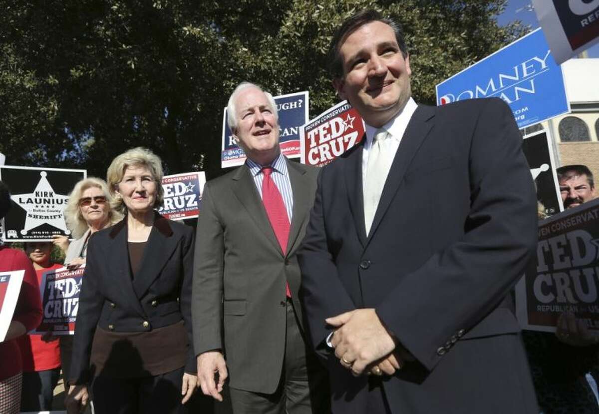 In this Nov. 1, 2012 file photo, then Republican candidate for U.S. Senate Ted Cruz, right, U.S. Senators Kay Bailey Hutchison, left, and John Cornyn listen to a question from reporters outside a polling station in Dallas. Cruz refused to endorse his colleague Cornyn before the 2014 Texas primary. But a resounding Cornyn victory has changed Cruz’s mind.