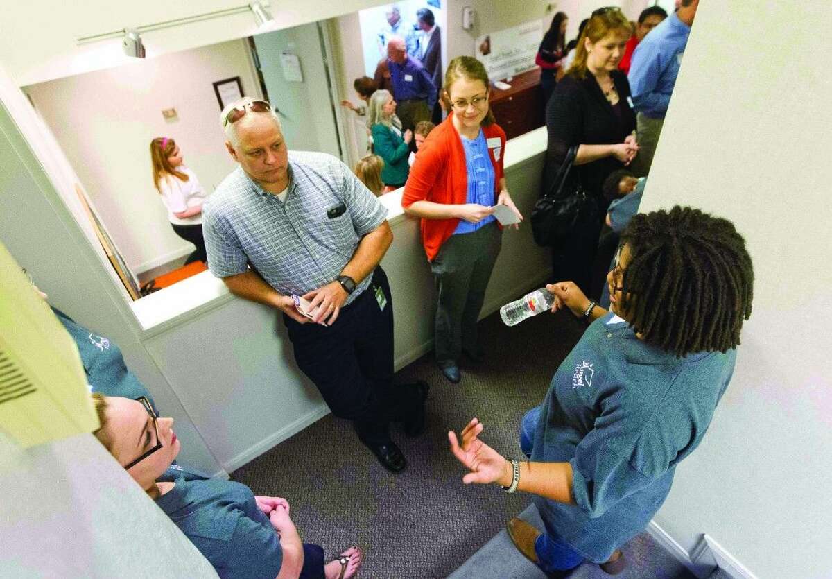 Visitors learn about the services that will be offered to homeless youth at the Community Youth Outreach Youth Resource Center grand opening in Conroe on Thursday.