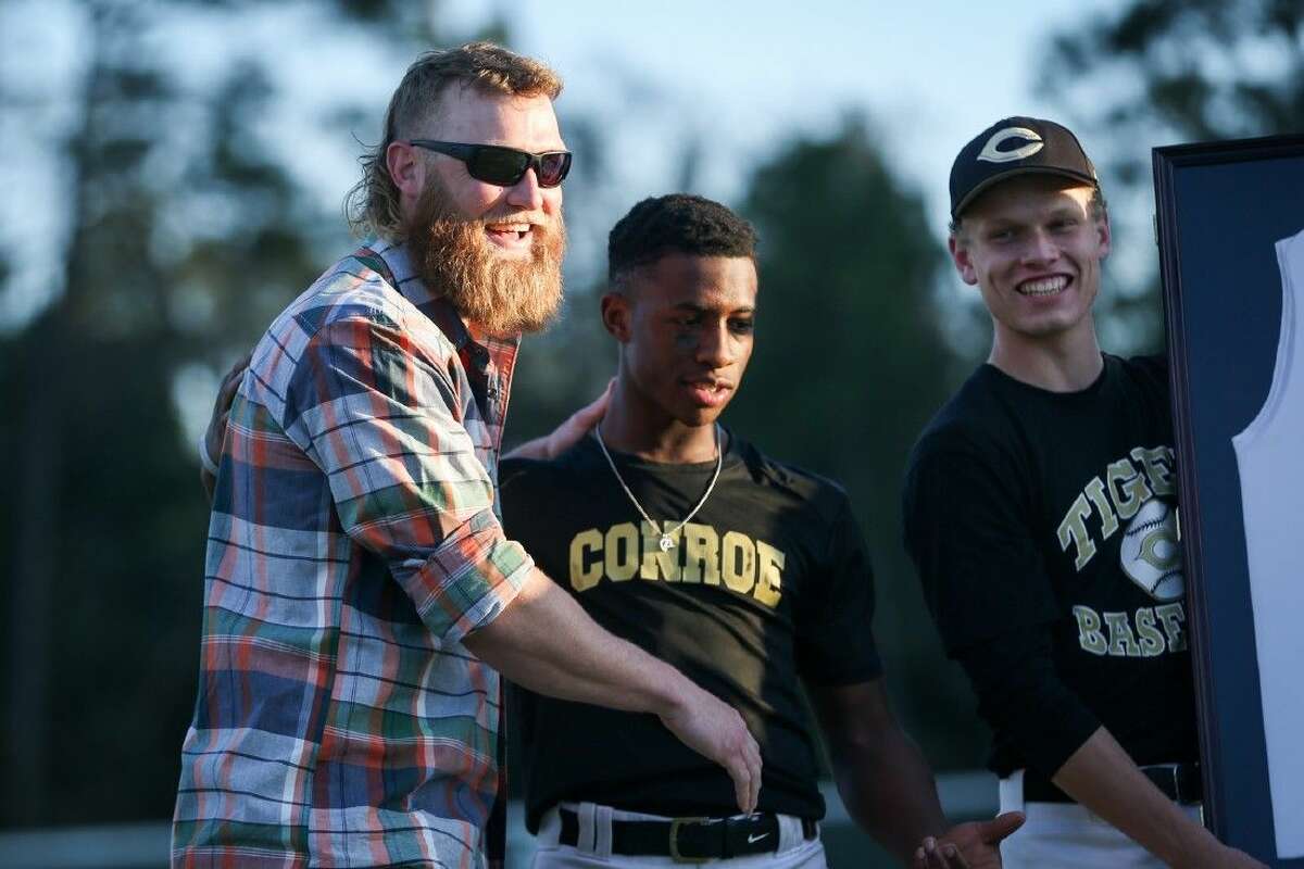 Conroe baseball alumnus Andrew Cashner jokes around with seniors from the Conroe baseball team during a ceremony to retire his number on Friday at Conroe High School.