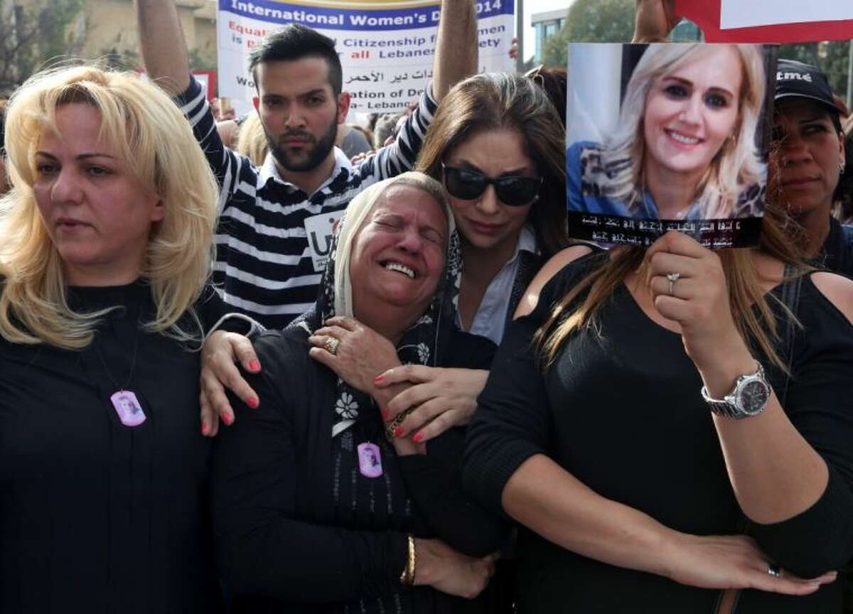 Nada Sabbagh, center, whose daughter was killed by her son-in-law, weeps while taking part in a rally making International Woman’s Day demanding that parliament approves a law that protects women from domestic violence in Beirut, Lebanon, Saturday.